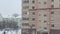 It's snowing. blurred background of falling large flakes of snow against the backdrop of residential buildings