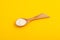 Xanthan Gum Powder in wooden spoon on yellow background. Food additive E415. Binding agent, Gluten free ingredient. Stabiliser,