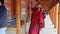 XIAHE, CHINA - AUGUST 24, 2018: People pass a row of praying wheels around Labrang Monastery in Xiahe town, Gansu