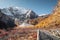 Xiannairi holy mountain with golden pine forest in autumn at Yading