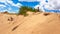 Xilinhot - A man in shorts sitting on a sand dune on Hunshandake Desert in the nearby of Xilinhot, Inner Mongolia