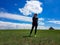 Xilinhot - A woman standing on a vast pasture in Xilinhot in Inner Mongolia. In the back there is a heap of stones (aobao)