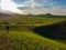 Xilinhot - A woman walking on a green hill in Xilinhot, Inner Mongolia. Endless grassland with a few wind turbines in the back