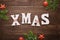 Xmas decorative text on wooden table surrounded with Christmas decorations