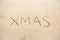 xmas hand writing on sand beach. christmas sign on natural brown background.celebrate christmas festival with the natural is conce