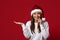 Xmas Offer. Cheerful Young Woman In Santa Hat Holding Invisible Object On Open Palm