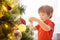 Xmas party celebration. Child decorating Christmas tree at home. Family with kids celebrate winter holidays. New year small boy at
