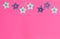 Xmas pink background with turquoise and purple wooden stars with carved in them deer, Christmas tree, snowflake, stars.