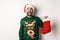 Xmas and winter holidays concept. Happy man got a gift in Christmas sock, looking excited, standing in Santa hat against