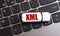 XML - the word on a white flash drive, lying on a black laptop keyboard