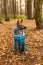 Xoloitzcuintle Mexican Hairless Dog  puppy with blue collar and  jacket sitting on autumn forest background