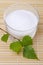 Xylitol birch sugar in glass bowl with birch leaves on bamboo mat