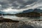 yacht boat stands at the pier against the backdrop of a picturesque mountain range, Norwegian seascape, rocky coast with