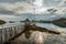 yacht boat stands at the pier against the backdrop of a picturesque mountain range, Norwegian seascape, rocky coast with