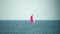 Yacht on calm sea. Luxury cruise trip. Side view of white boat with pink sail on deep blue water. Aerial view of rich