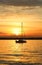 Yacht drifting on the lake during beautiful summer sunset.