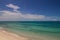 Yacht on the horizon between a green ocean and the blue sky