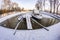 Yacht and jetty in a winter harbor covered in ice and snow, bridge and trees in the background. Winter