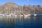 Yacht moored in dark blue sea with mountain and blue sky background in Hout Bay Harbor, Cape Town