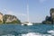 Yacht in the ocean, surrounded by cliffs.