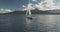 Yacht racing at ocean bay coast aerial. Passengers on sailboat at open sea at summer cloudy day