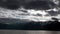 Yacht rails on background of dark gray clouds in sky and snow mountain tops.