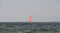 Yacht with red balloon sail seen on the ocean with a storm coming up