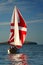 The Yacht with a red sail near island. 2