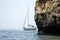 Yacht sailing by cliff