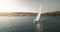 Yacht sailing at ocean bay aerial. Summer nobody nature seascape. Sailboat sun reflection. Port town
