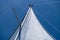 Yacht sails on clear blue sky background. Sailing with the wind at open sea ocean, summer holidays