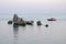 Yacht sails past the rocks in the sea