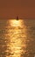 Yacht silhouetted against a golden sea.