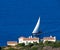 Yacht with white sail swim to the shore of Crete.