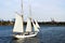 Yacht with white sails and passengers on the background of Governors Island near New York.