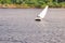 Yacht with white sails at Volga river. Sailboat tilted in a gust of wind. Boat with a sail is sinking
