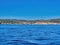 Yachts anchored in calm bay. Blue ocean water with vanishing points provided by the natural curve of the sea wall. Istrian island