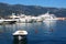 Yachts and boat anchored in port near mountains