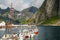 Yachts and boats with mountains in the background at pier in Reine, Moskenesoya, Lototen islands,, Nordland County, Norway