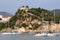 Yachts sail near a fortress on a hill Parga Greece