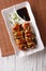 Yakitori chicken with green onions on a plate. vertical top view