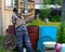 Yakut Asian girl carefully washes iron tanks to collect drinking rain water near a residential wooden house.