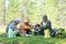 A Yakut family on a picnic lays out food on the grass in a field near the Northern wild forest