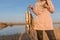 Yakut girl fisherman hard holds in the hands of many caught fish pike hanging on Fish Stringer on backdrop of lake.