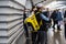 A Yandex delivery courier with a yellow bag is waiting for a train in the subway to deliver the order to the buyer