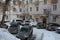 Yard with parked cars narrow passage covered with snow in winter at the old residential apartment
