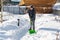 The yard was covered with snow after a heavy snowfall. A man cleans the garden paths from snow on a sunny day in winter. The