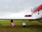 Yaslo, Poland - july 1 2018:A little girl hides from the rain under the wing of a light two-seater turboprop aircraft during an ai