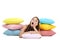 Yawning girl with colorful pillows