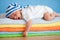 Yawning sleeping baby on colorful towels stack